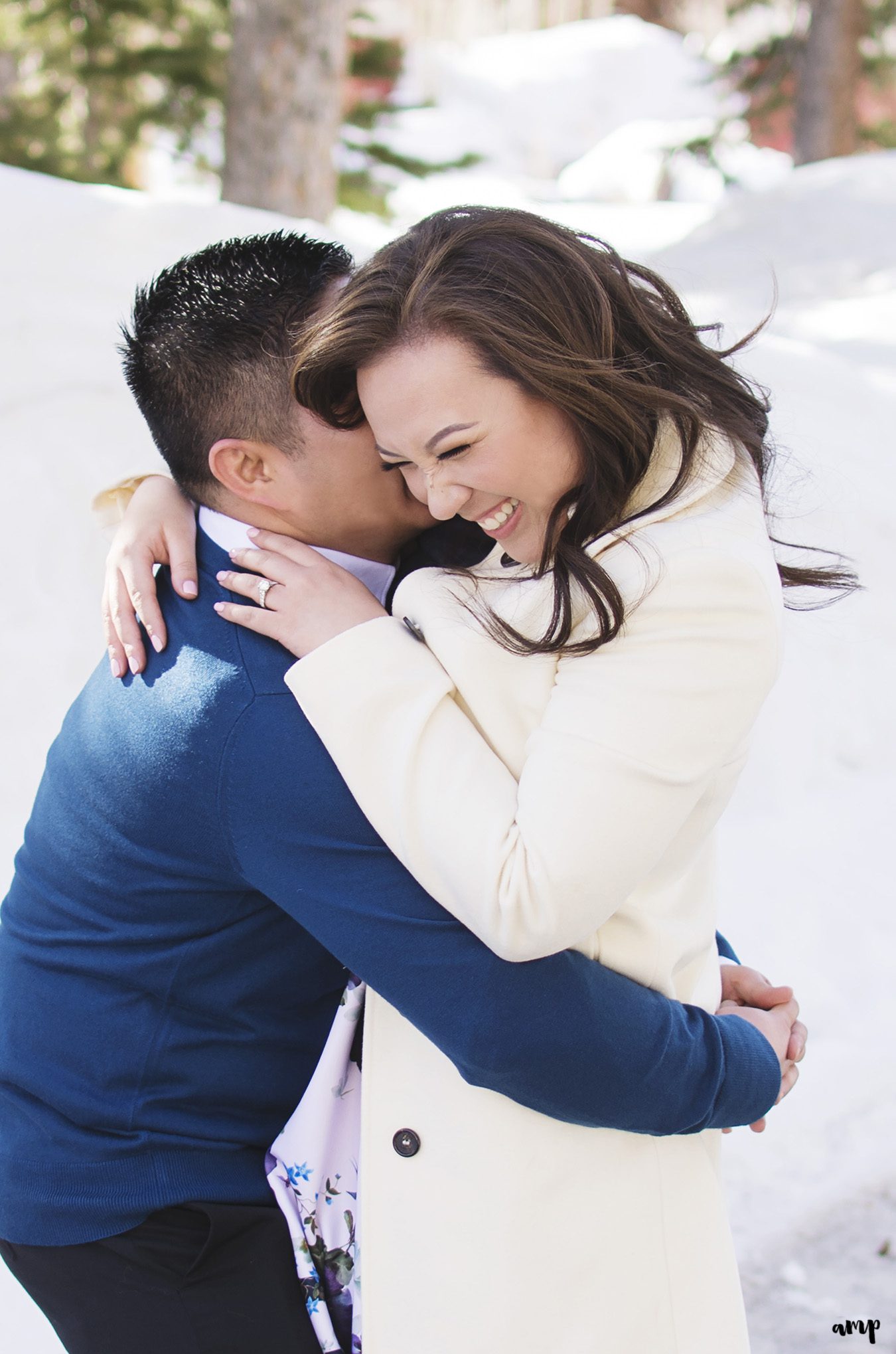 Engaged couple laughing in the snow