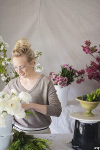 Kelly Mendenhall of 3 Leaf Floral arranging a centerpiece