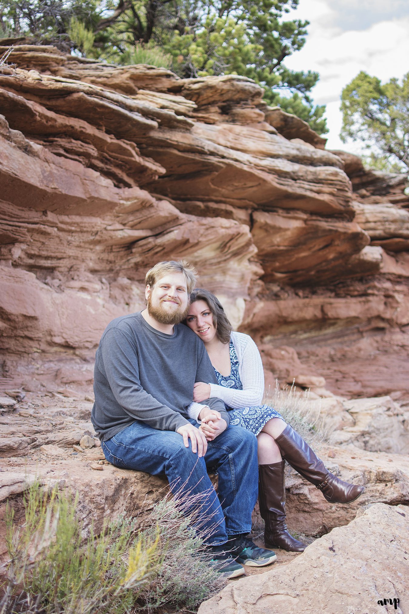 Engaged couple sitting in Colorado National Monument desert