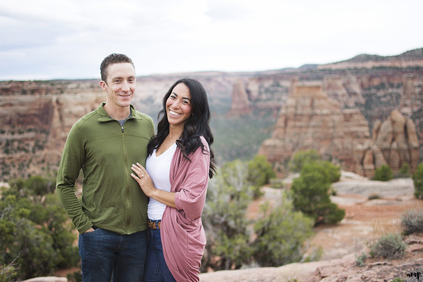 Engaged couple standing before a canyon in the Colorado National Monument