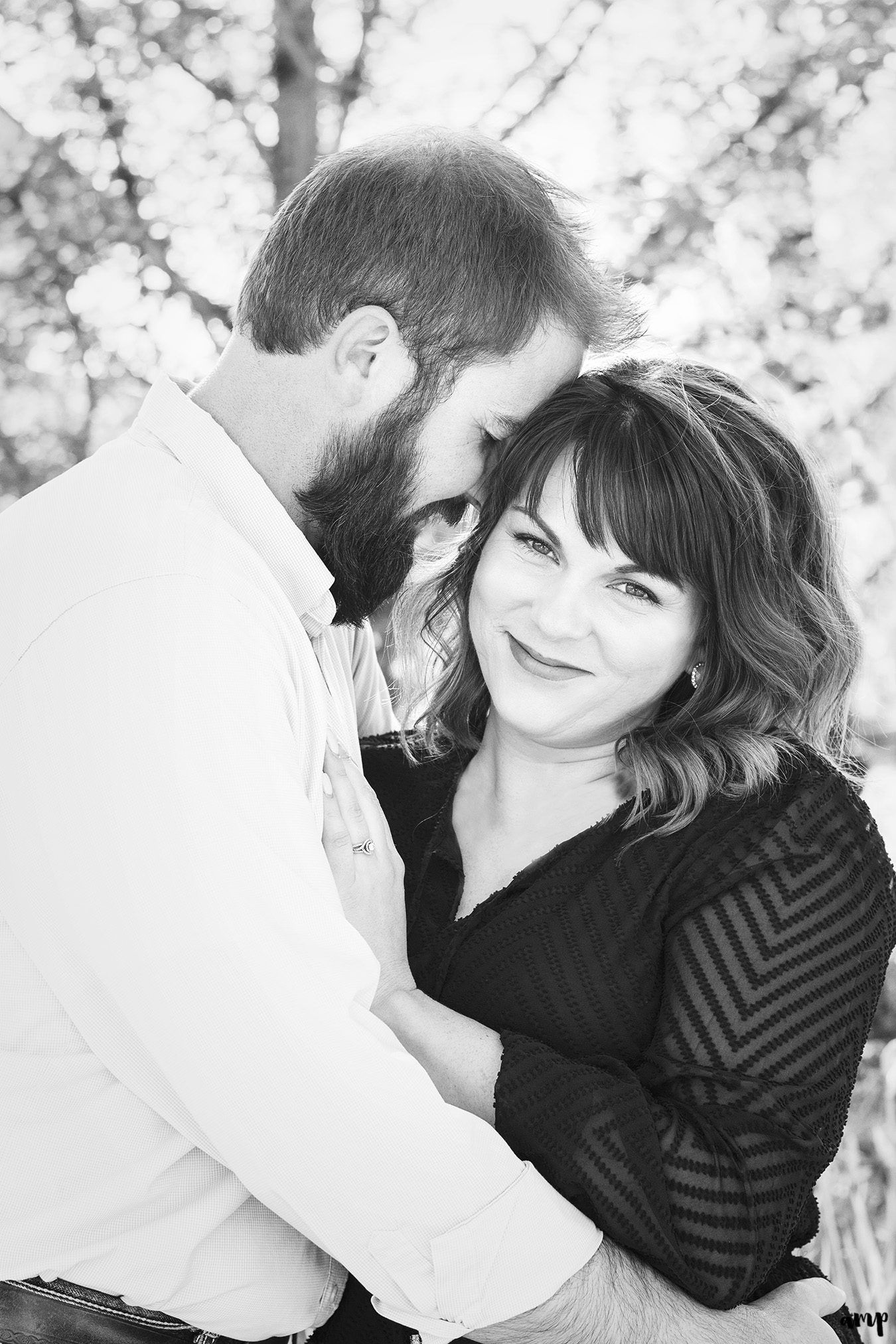 Black and white photo of engaged couple cuddling