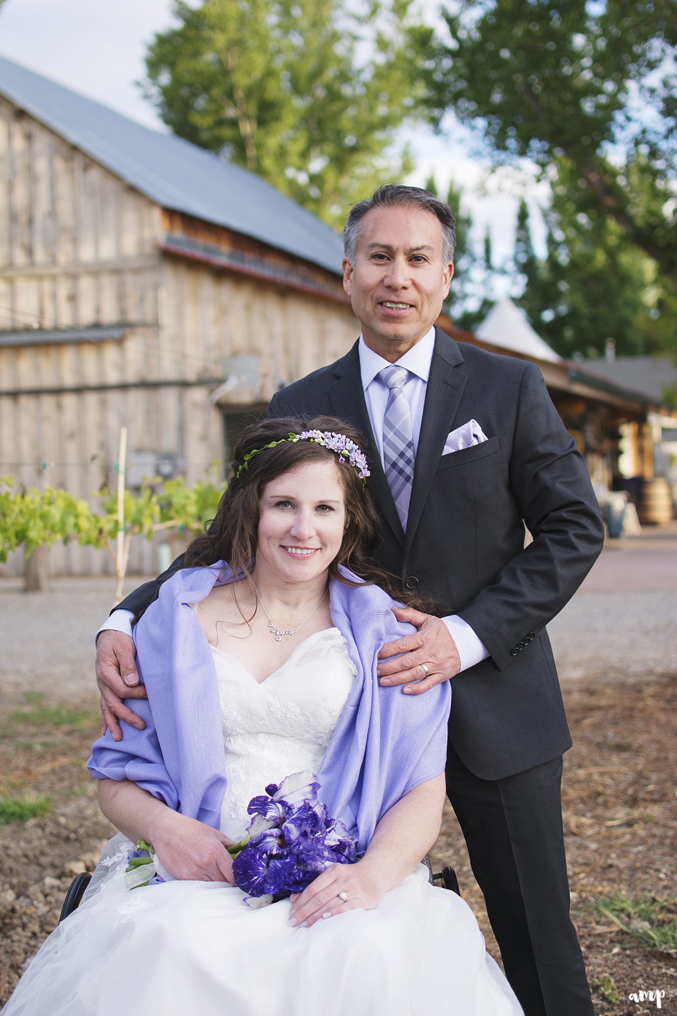 Newlywed couple with bride in wheel chair outside a winery
