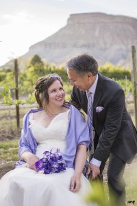 Couple gazing at each other in a vineyard with Mt. Garfield in the distance