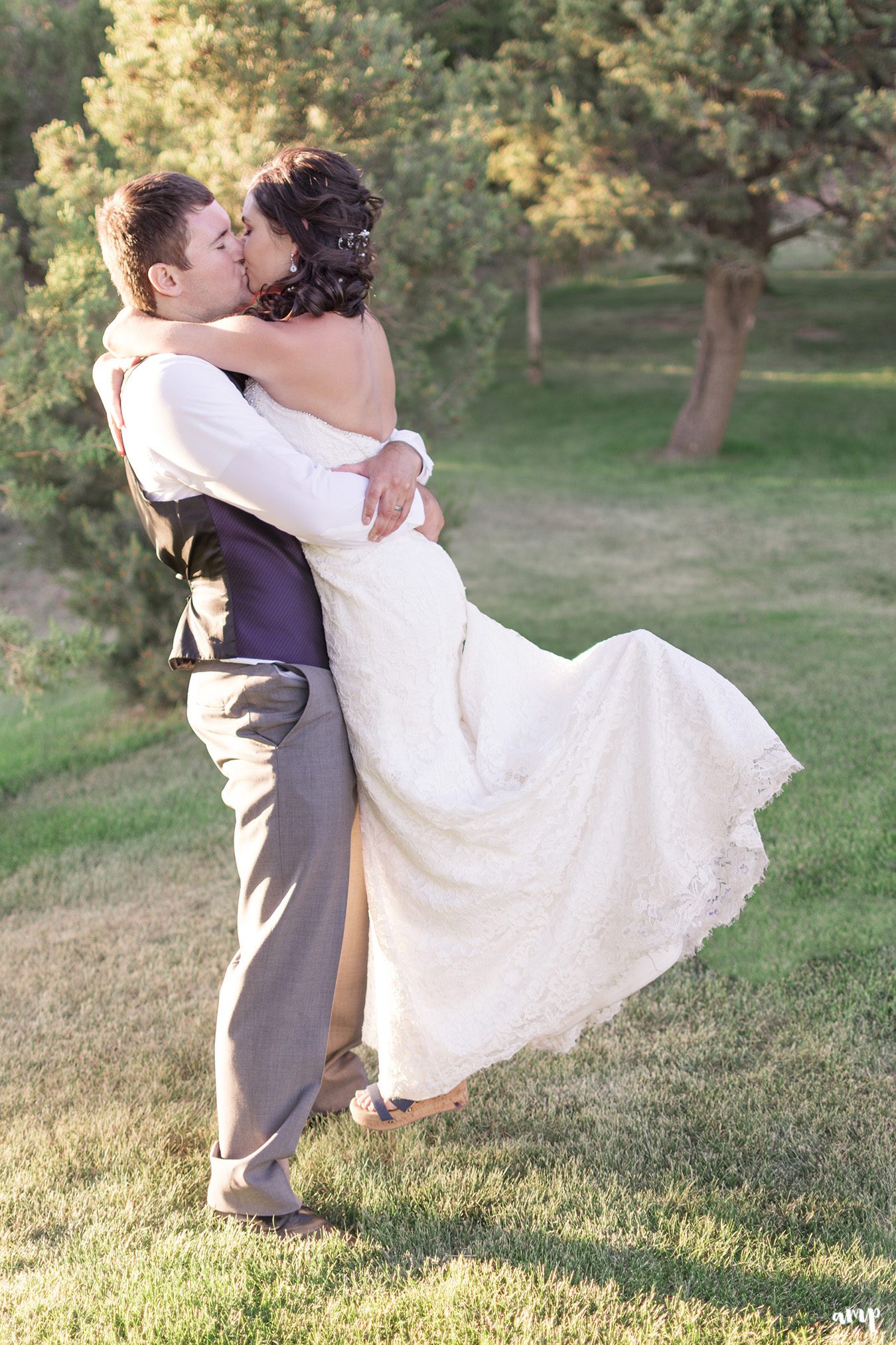 Groom lifting bride at sunset