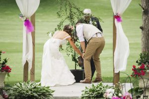 Bride and groom water their wedding tree