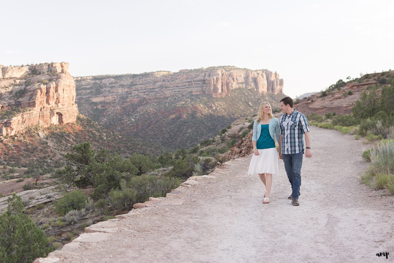 Couple walking hand-in-hand in the desert of the Colorado National Monument