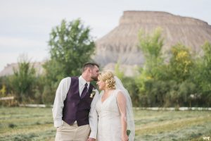 Bride and Groom posed beneath Mt. Garfield in Grand Junction