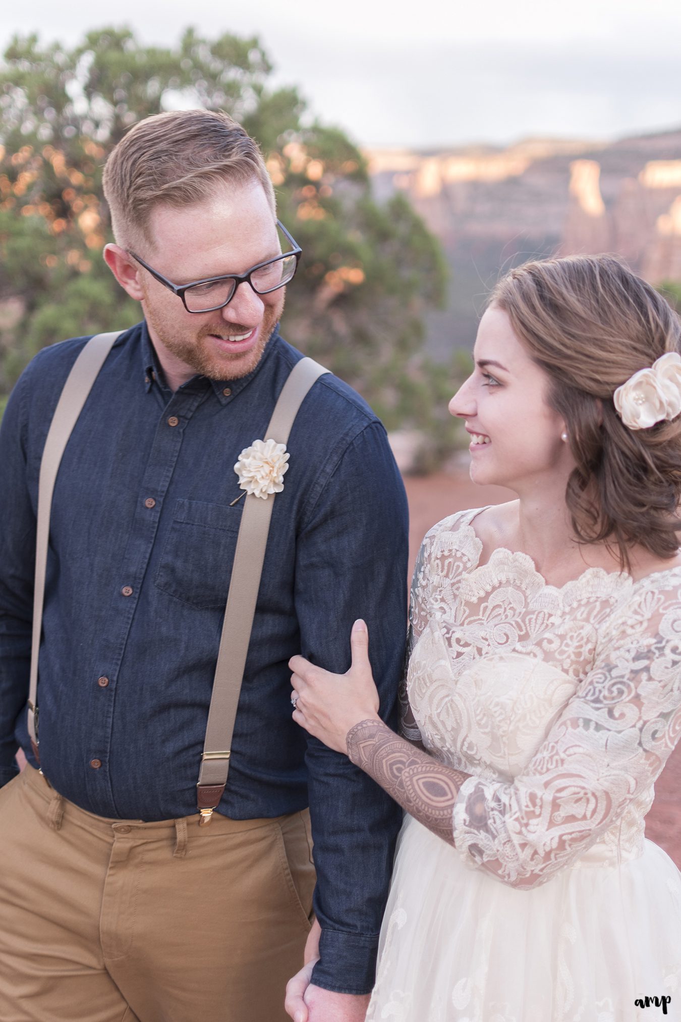 Bride and groom laughing and walking on the Colorado National Monument