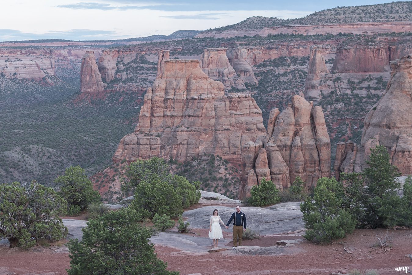 Bride and groom with the monument valley below