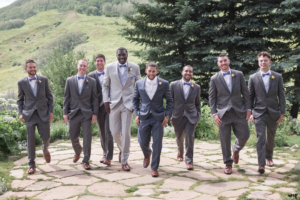 Groomsmen walking toward the camera with mountains in the back