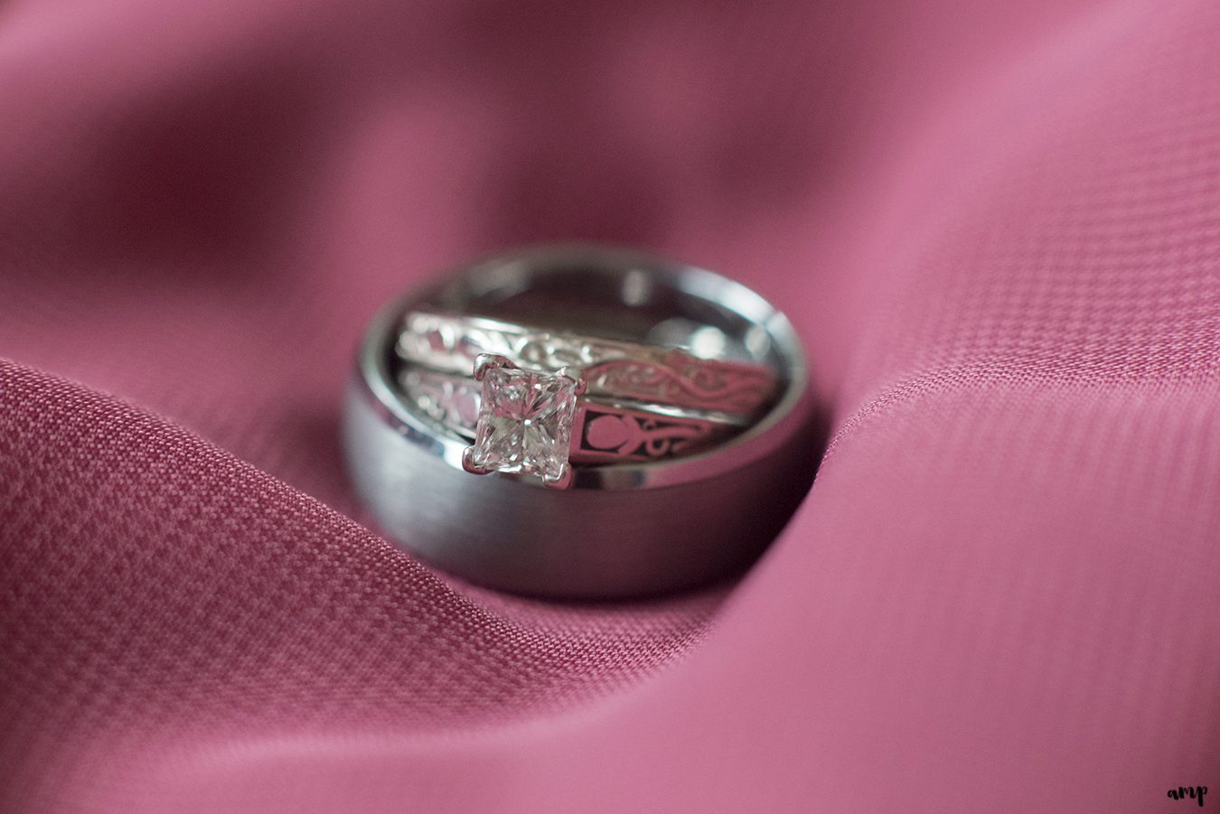 Wedding ring detail shot on magenta bridesmaids dress