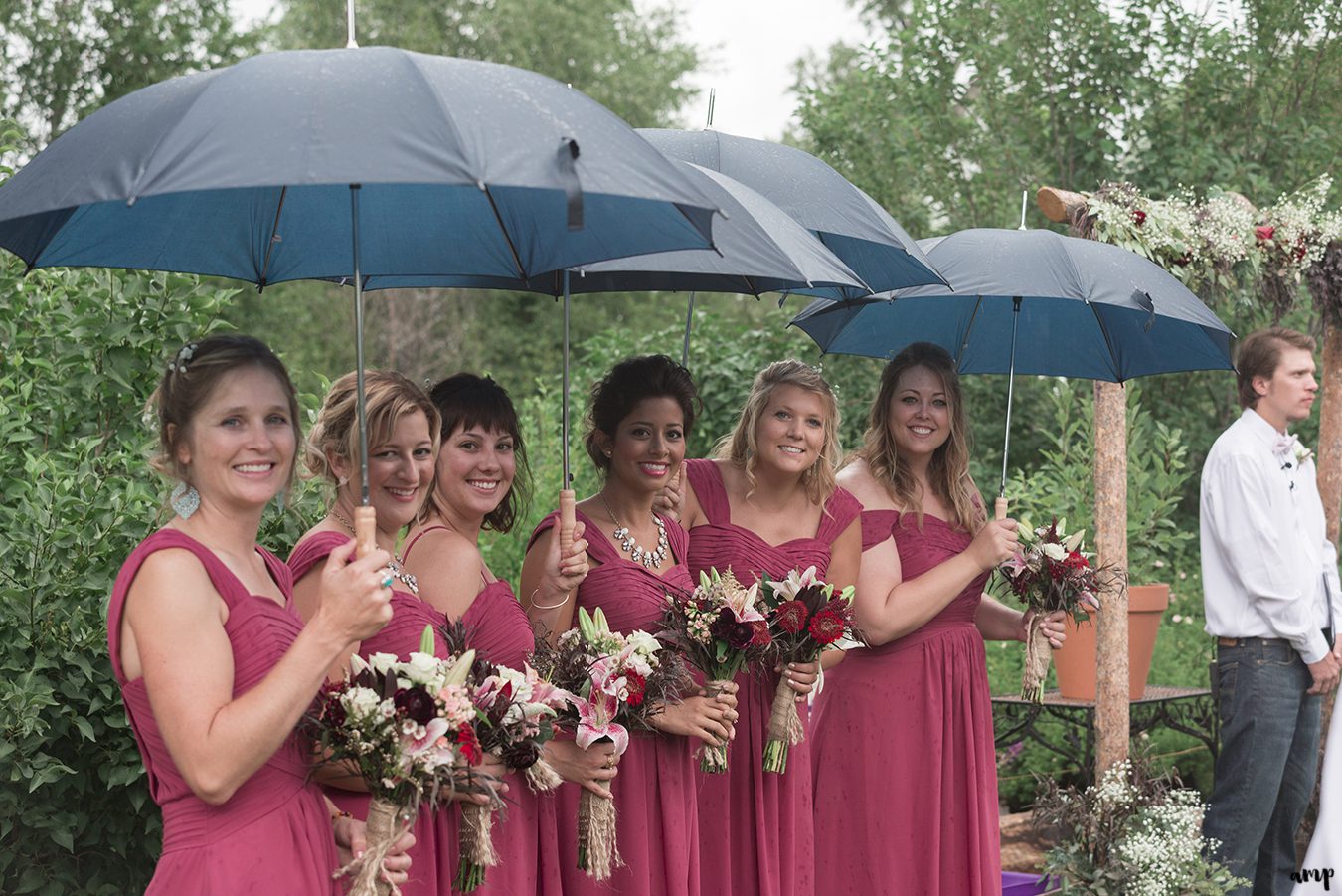 Bridesmaids under umbrellas at the Gunnison wedding along Ohio Creek