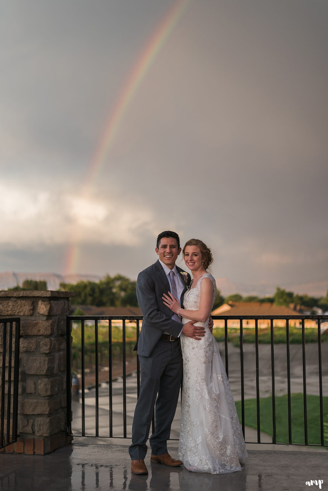 Bride and groom beneath a rainbow on their wedding day