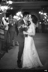 Bride and groom share a kiss during their sparkler exit