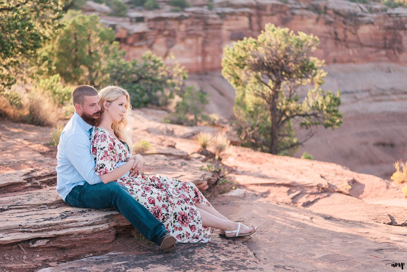 Engaged couple sitting looking over the canyon of the Colorado National Monument