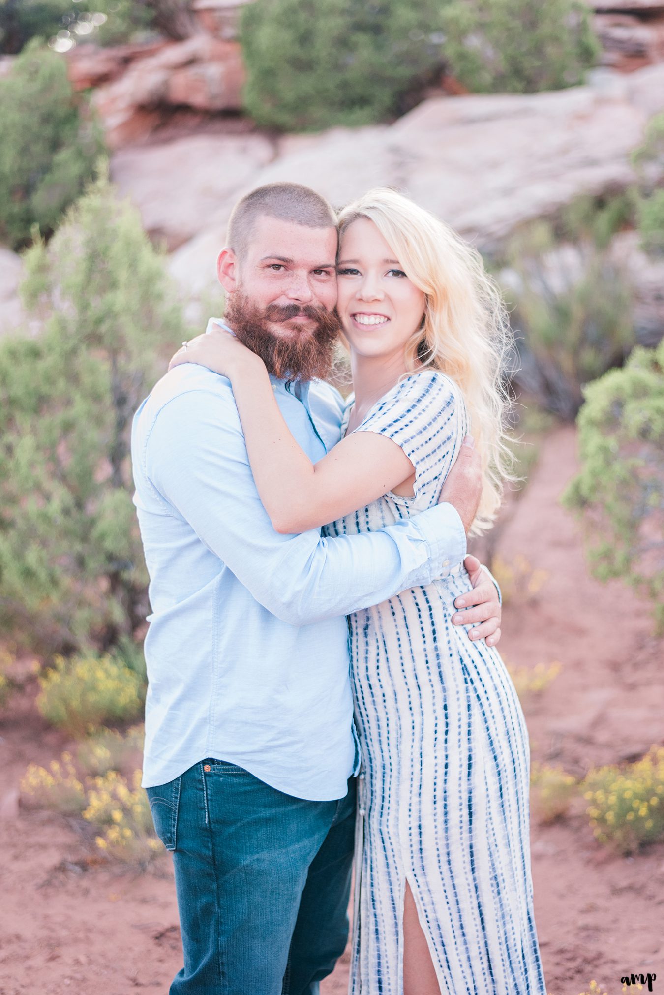 Engaged couple hugging in the desert of the Monument