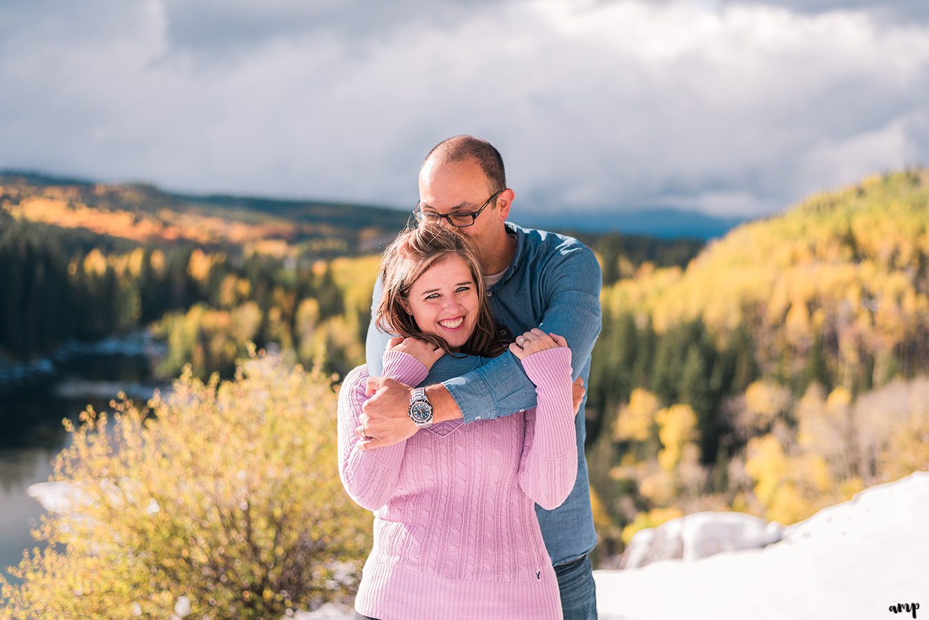 Couple snuggles among the fall yellow aspens of the Grand Mesa