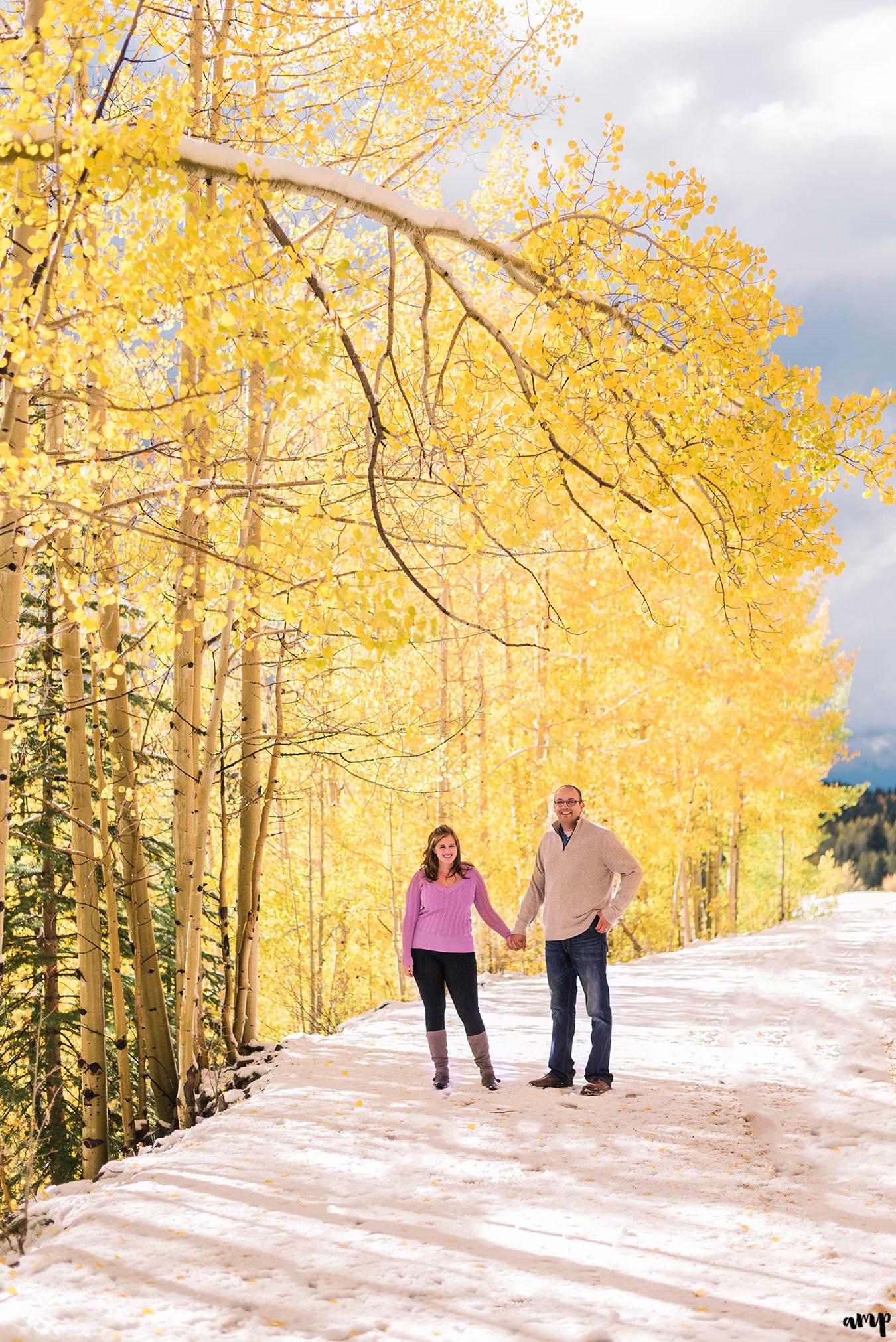 Couple walking through yellow fall aspens