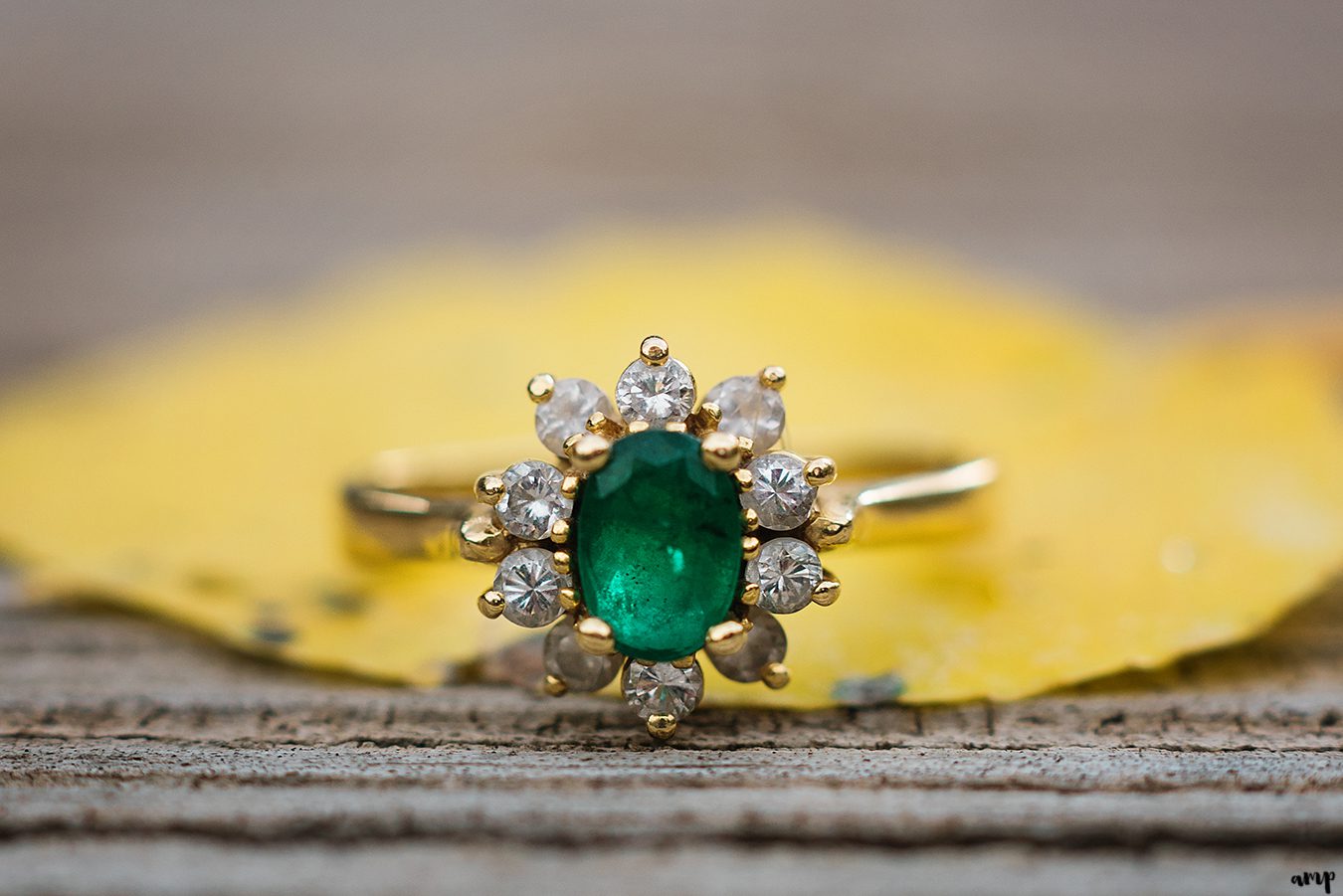 Emerald and diamond engagement ring on an aspen leaf