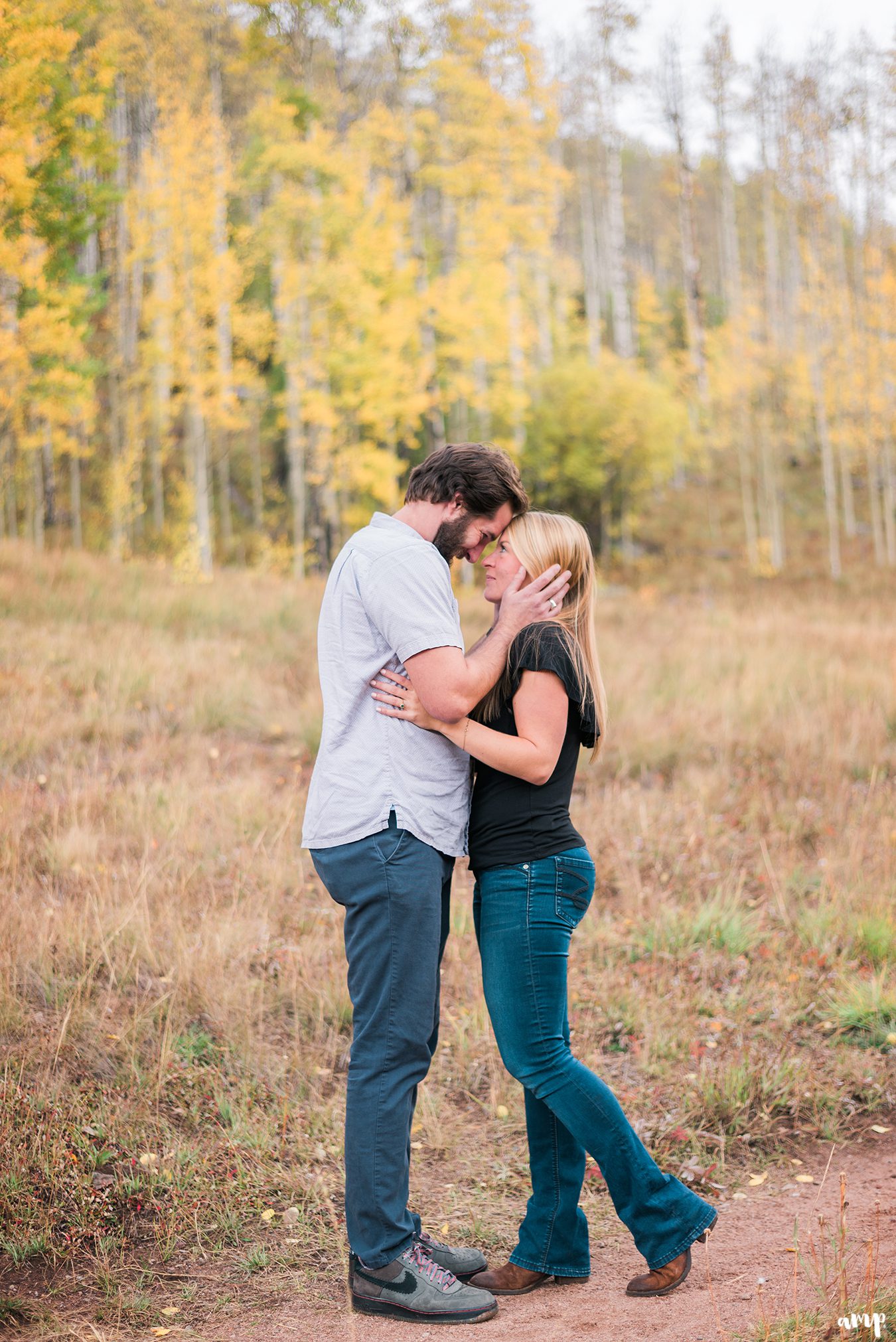 Engaged couple kissing in the fall leaves at Piney River Ranch in Vail