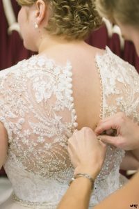 Doing up the bride's dress with a crochet hook