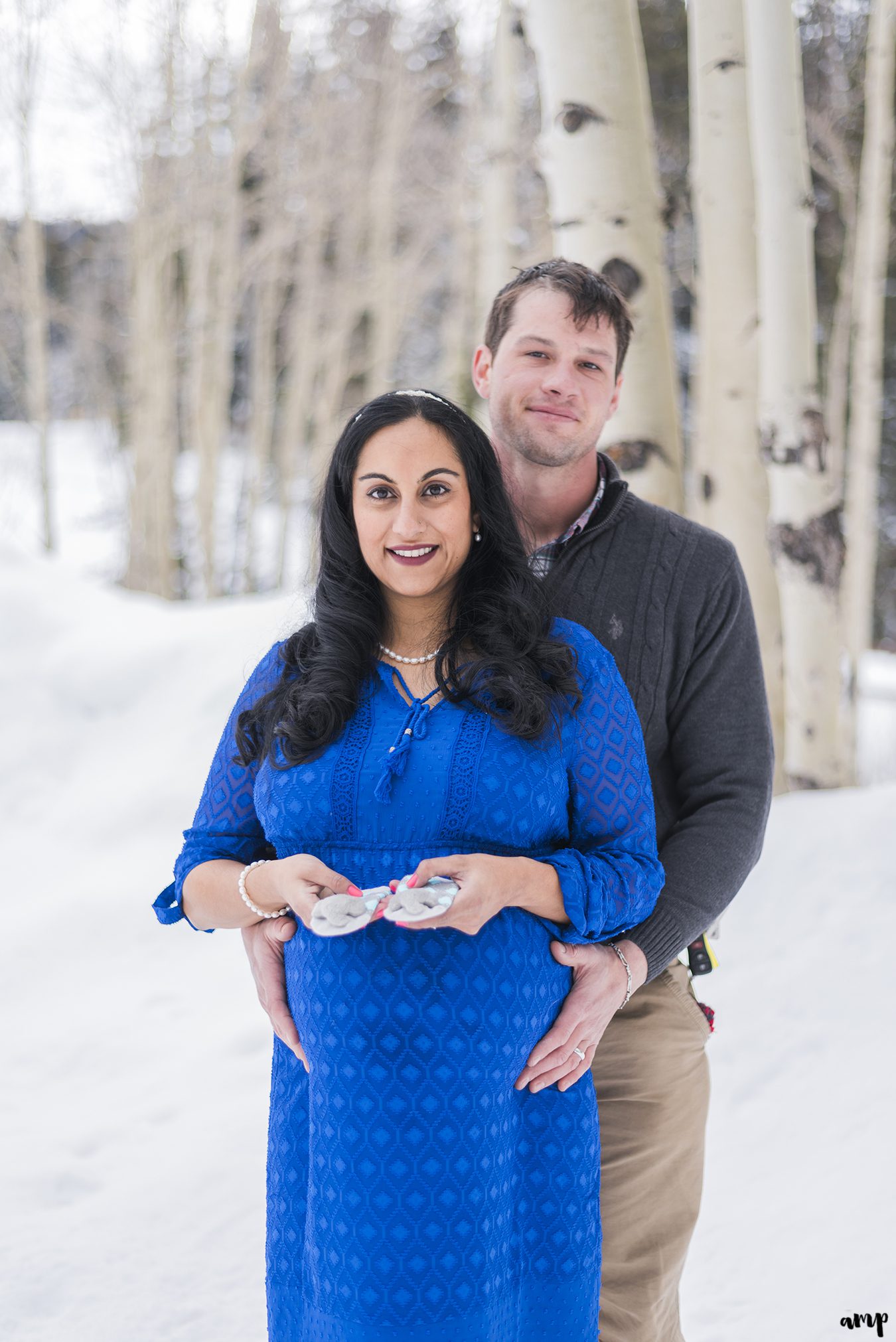 Expecting couple poses with baby booties