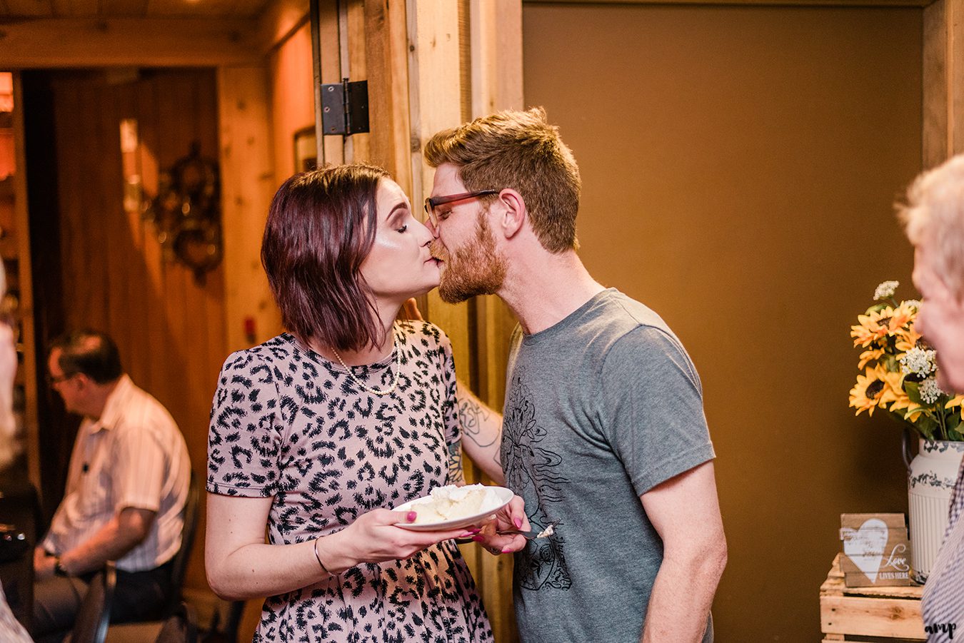 Ben and Courtnee share a kiss after cutting the cake at the Wine Dive in Wichita