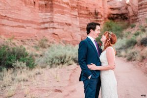 Blake and Carrie cuddle amid a red rocks canyon in Gateway