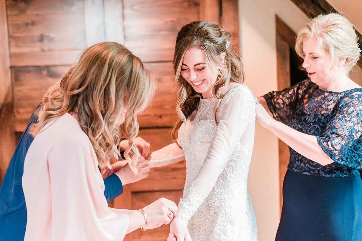 Bride's family helping her get into dress