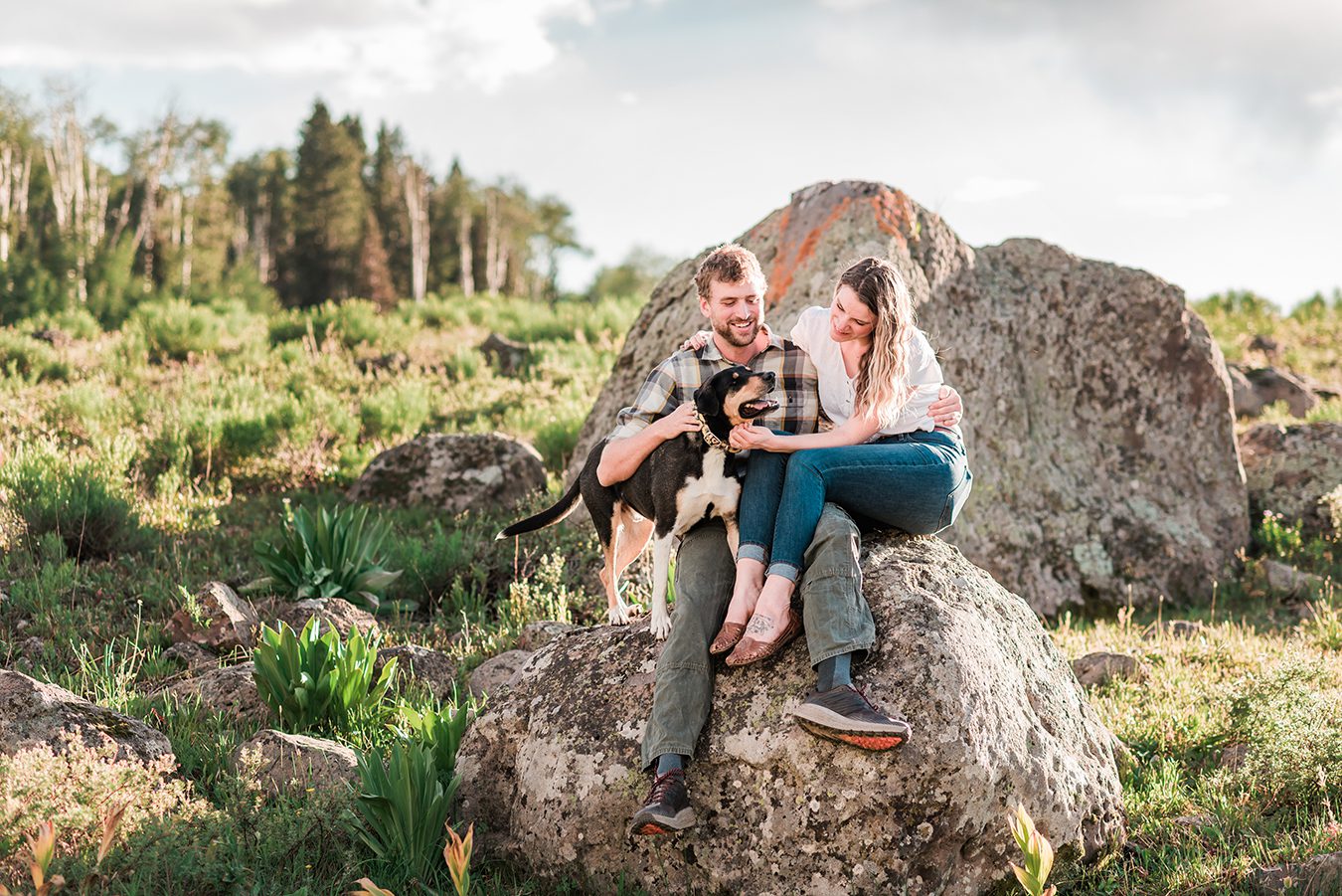 Annie & Taylor sit on a boulder with their dog for their Glenwood Springs Engagement Photos