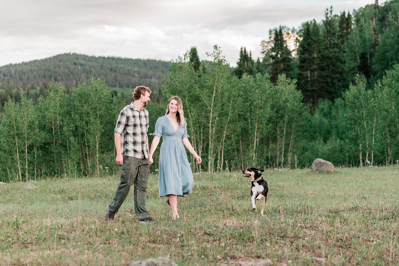 Annie & Taylor walking through a field of wildflowers for their Glenwood Springs Engagement Photos