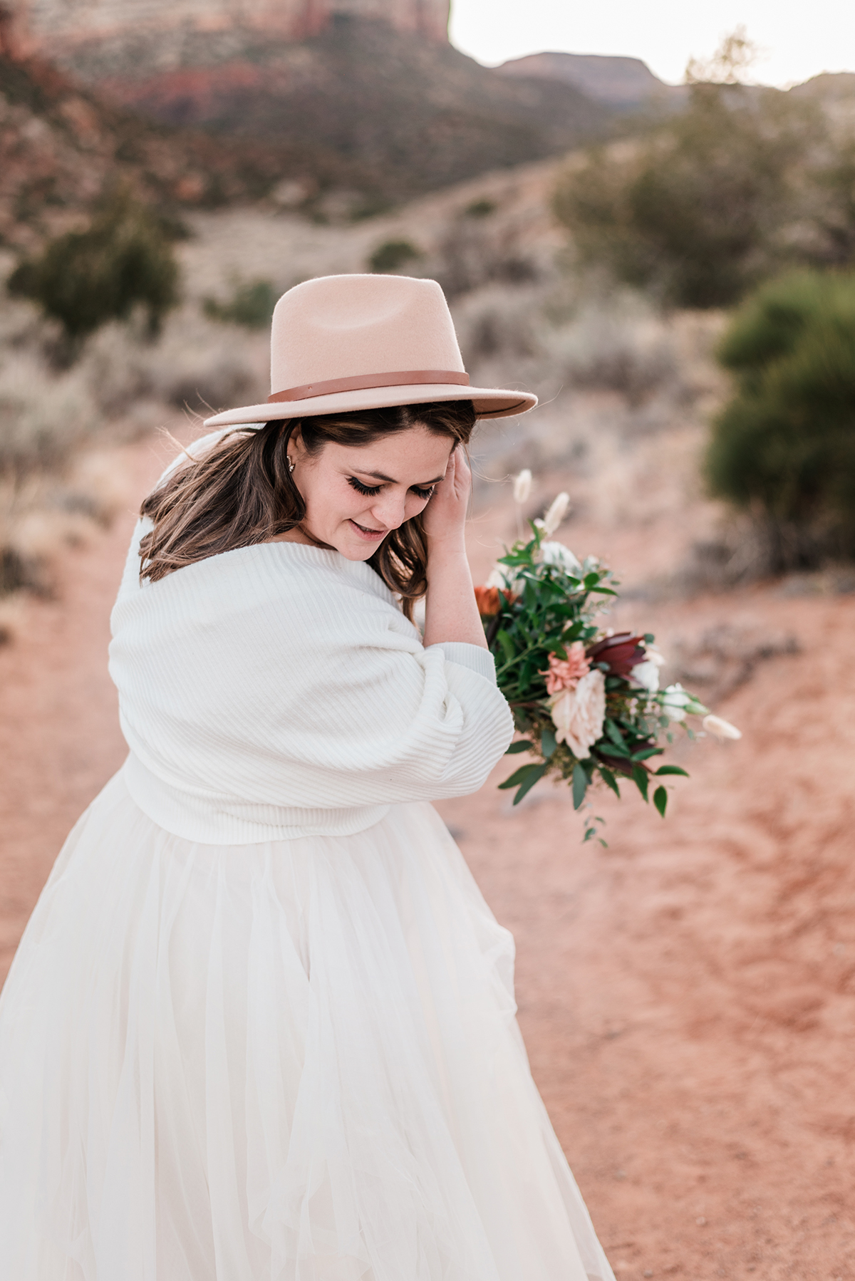 Bride with a shawl and hat on in the desert
