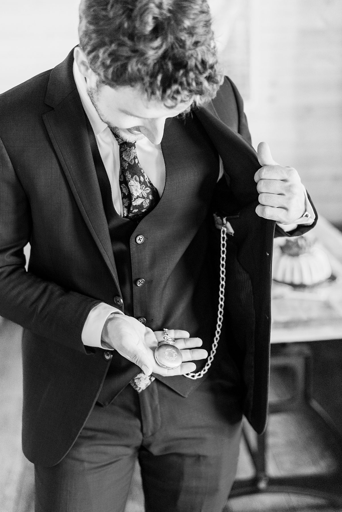 Groom wearing and holding a pocket watch