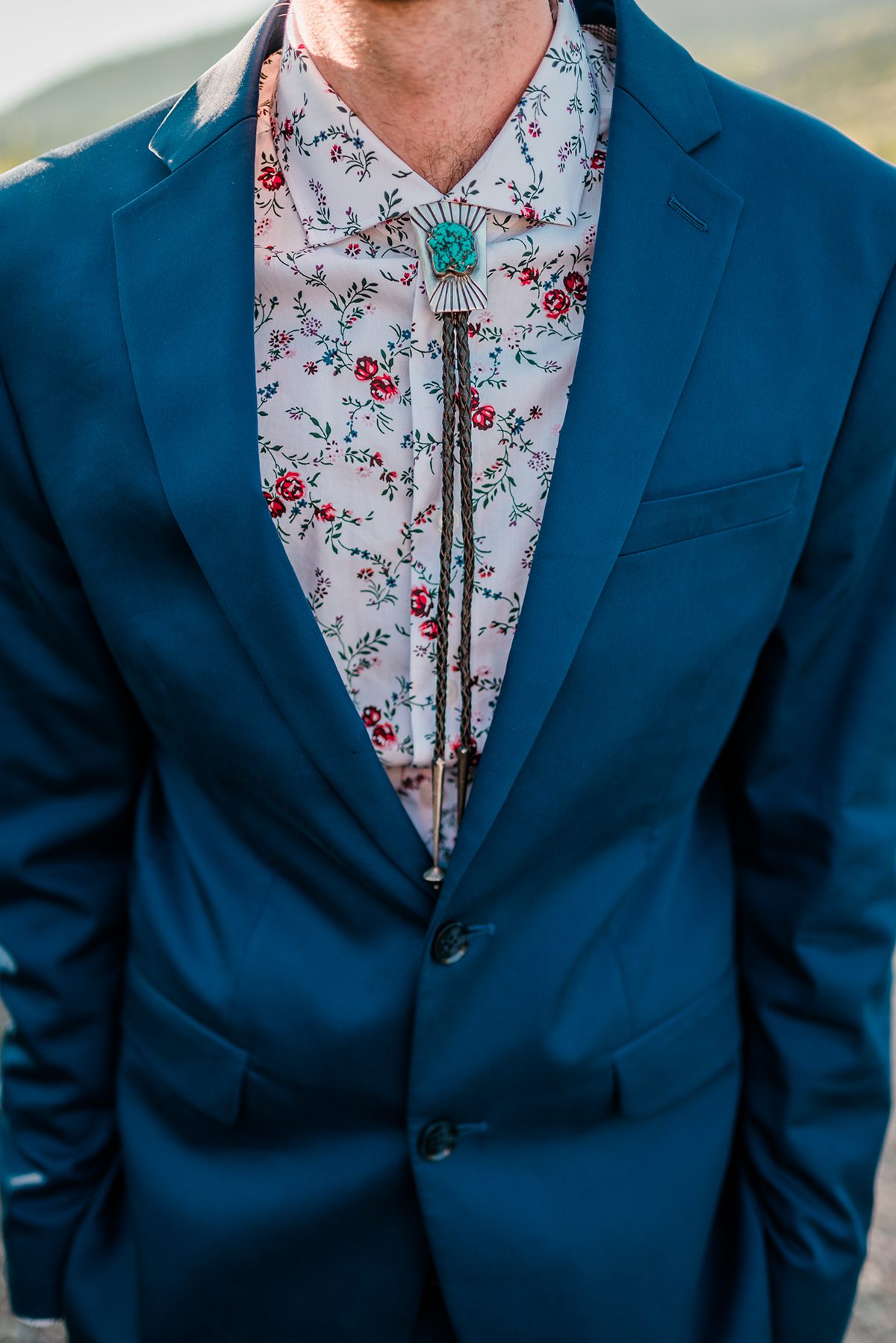 Groom wearing patterned shirt with bolo tie