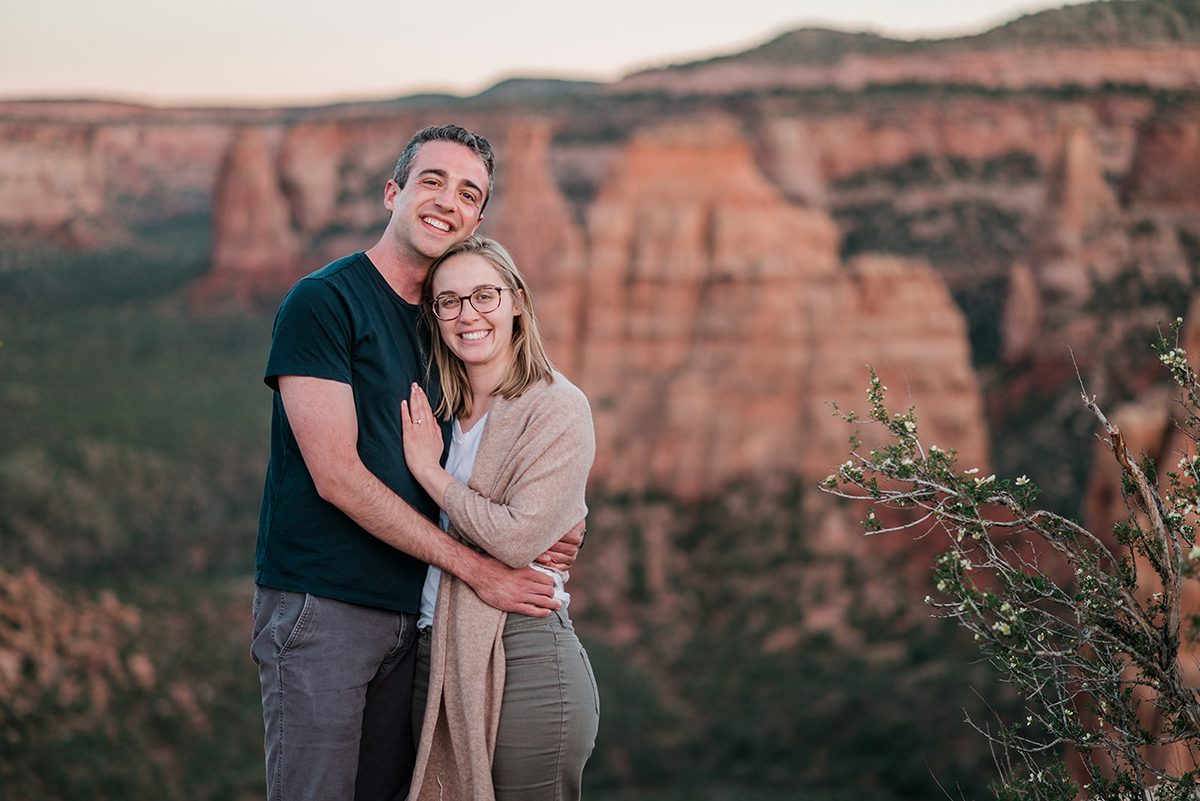 Eric and Colette pose for a photo in front of Independence Monument, a red rock pillar