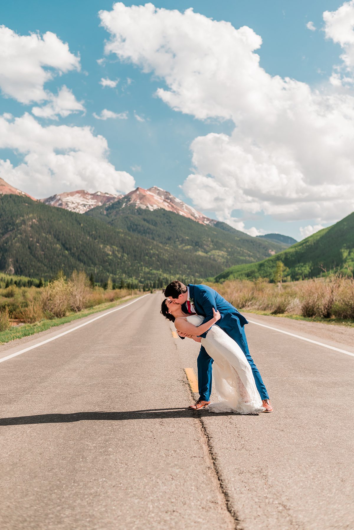 mckade dips andrea for a dramatic kiss in the middle of the road with red mountain behind