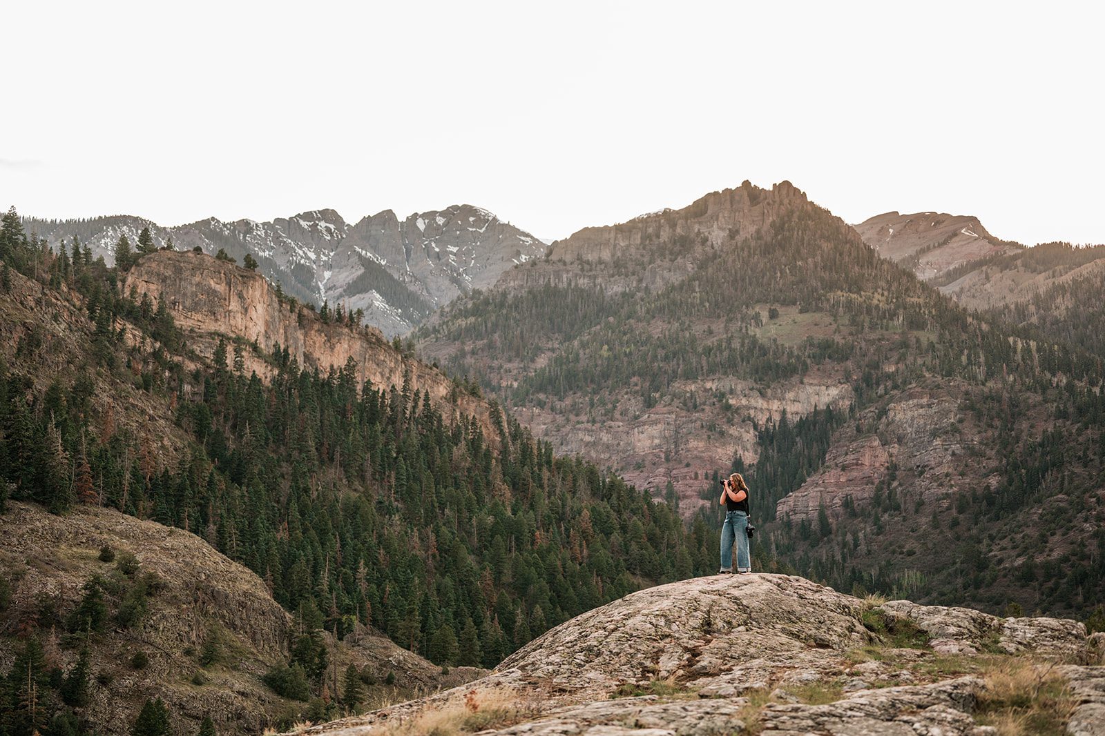 Ouray branding photos — female photographer with camera in mountain landscape